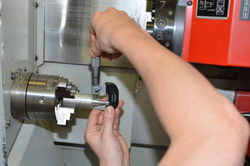 CNC-Drehmaschine, Werkstück wird mit einer Mikrometerschraube gemessen